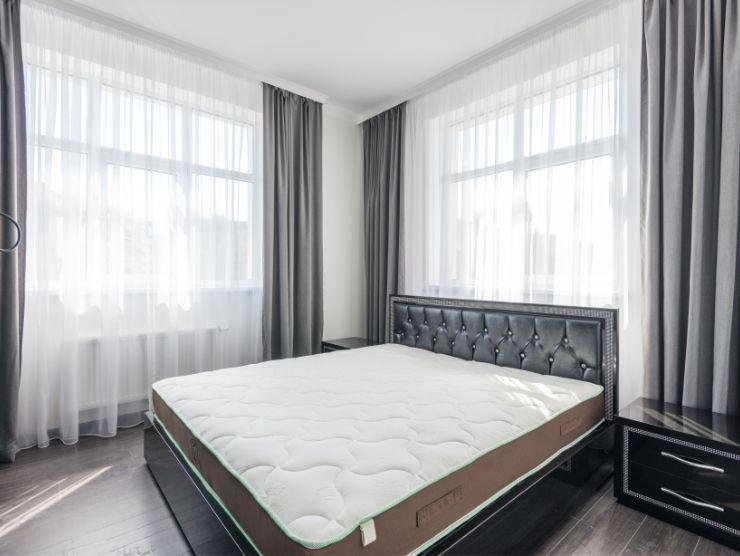 camera da letto con letto senza lenzuola e materasso in mostra